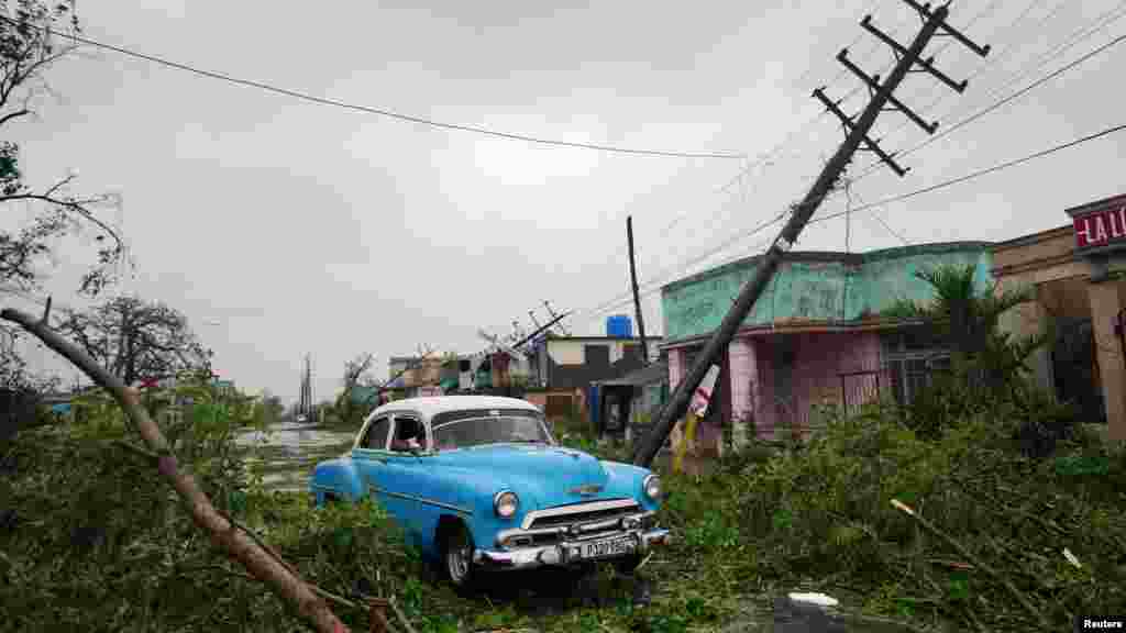 Un automóvil antiguo pasa por los escombros causados por el huracán Ian a su paso en Pinar del Río, Cuba.